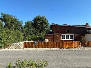 Das gleiche Gebäude von der Straße aus gesehen mit Bäumen dahinter
