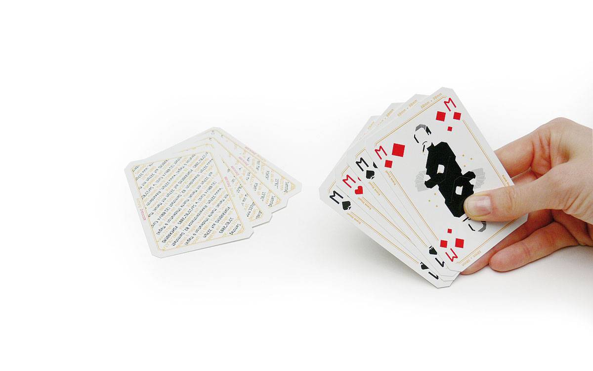 Eine Hand hält mehrere Spielkarten, daneben liegt ein Stapel weiterer Karten auf einem weißen Hintergrund.