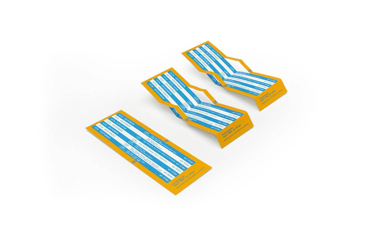 Drei Papierobjekte in Form von blauen und weißen Liegestühlen mit gelbem Rand auf weißem Hintergrund.