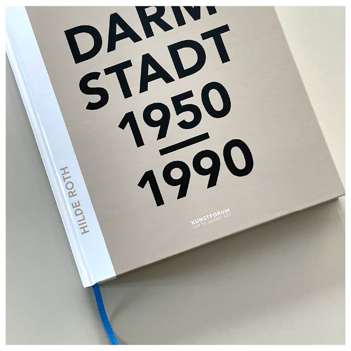 Buch mit dem Titel „Darmstadt 1950–1990“ von Hilde Roth auf hellem Untergrund, blauer Leseband sichtbar.