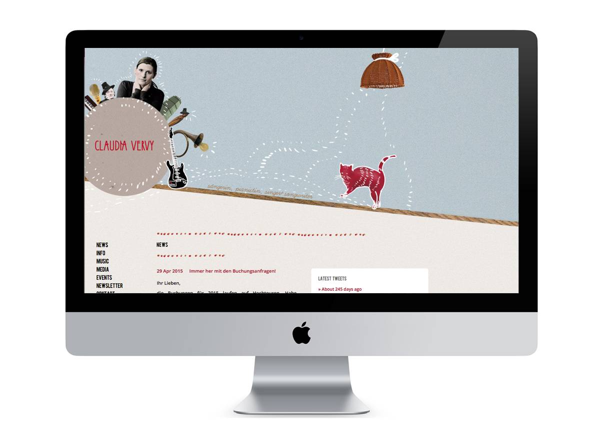 Computerbildschirm mit einer Website, die "Claudia Very" zeigt, links ein rundes Feld mit Namen, daneben eine Gitarre, oben eine Collage mit Person, Musikinstrumenten und rechts eine gezeichnete rote Katze unter einer Lampe.
