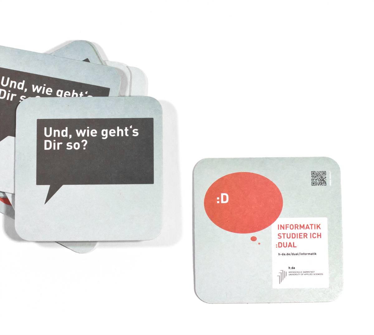 Zwei quadratische Bierdeckel; einer mit der Sprechblase „Und, wie geht’s Dir so?“, der andere mit einem roten Kreis „:D“ und Text „INFORMATIK STUDIER ICH :DUAL“.