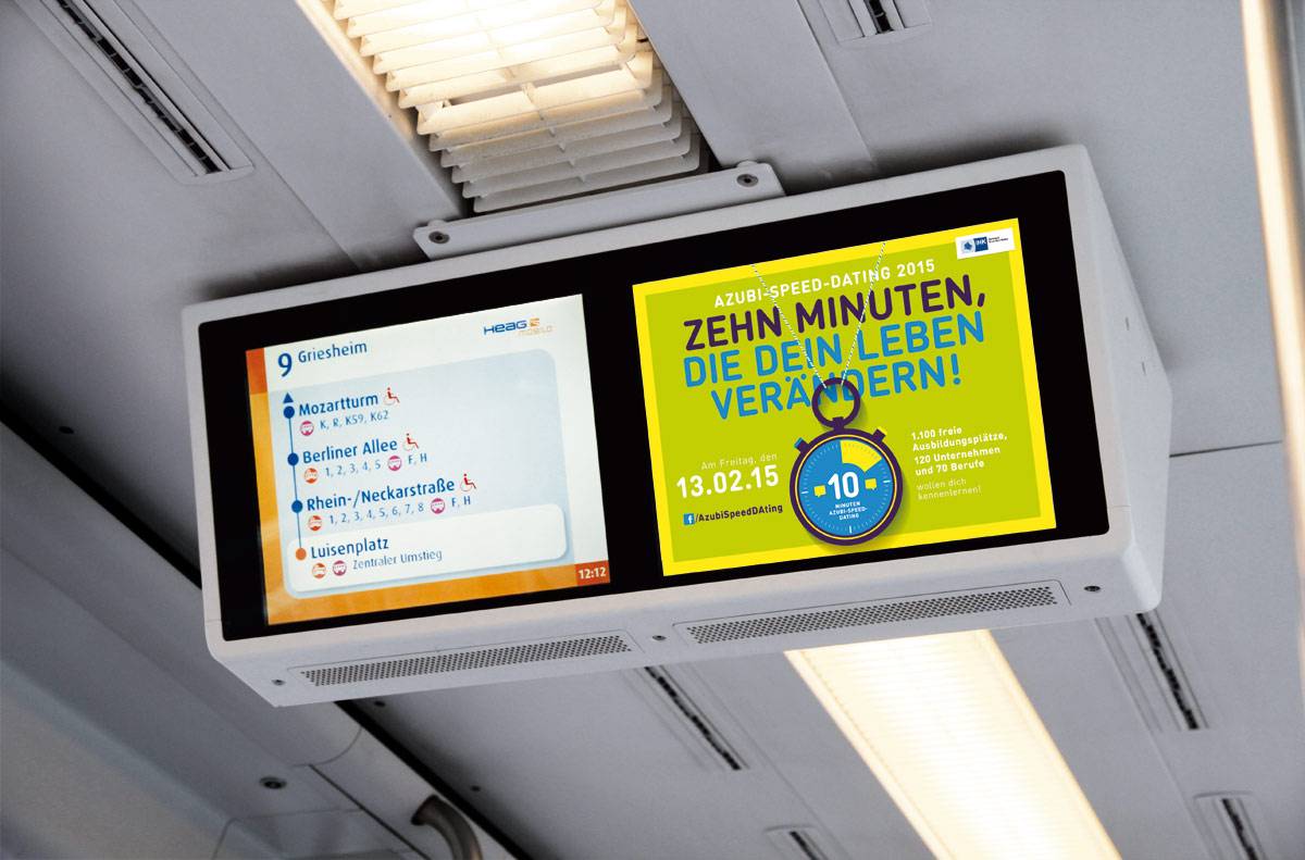Zwei Bildschirme in einer Straßenbahn zeigen links die nächste Haltestelle und Umsteigemöglichkeiten, rechts eine gelbe Werbeanzeige für ein Azubi-Speed-Dating.