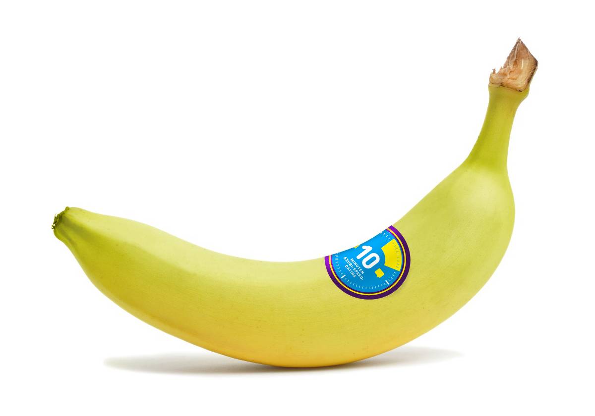 Eine einzelne gelbe Banane mit einem blauen Aufkleber auf der Schale, vor weißem Hintergrund.