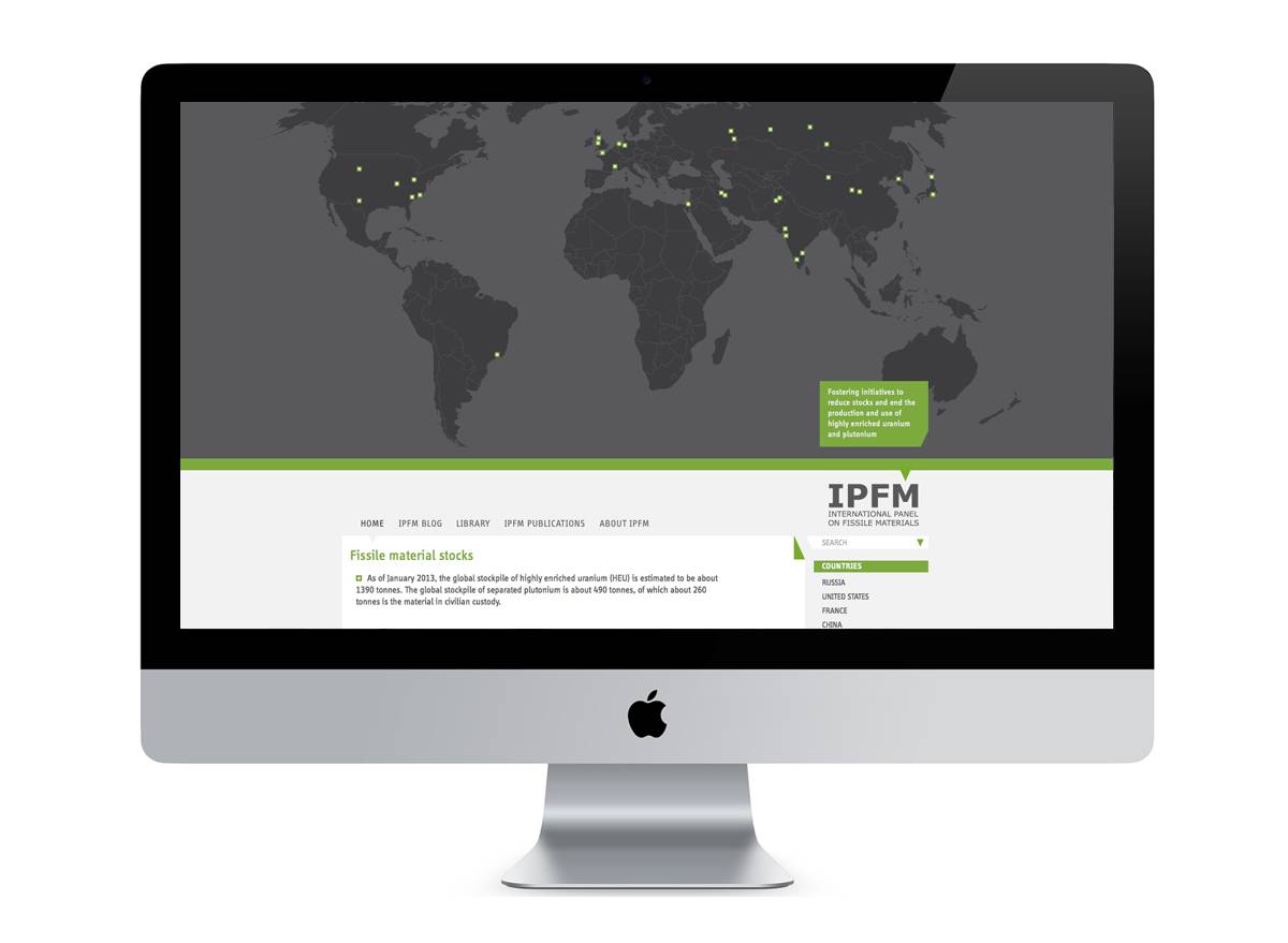 Ein iMac-Bildschirm zeigt eine Webseite mit einer Weltkarte, auf der grüne Punkte Standorte markieren; darunter steht „IPFM International Panel on Fissile Materials“ und ein Text zu spaltbarem Material.