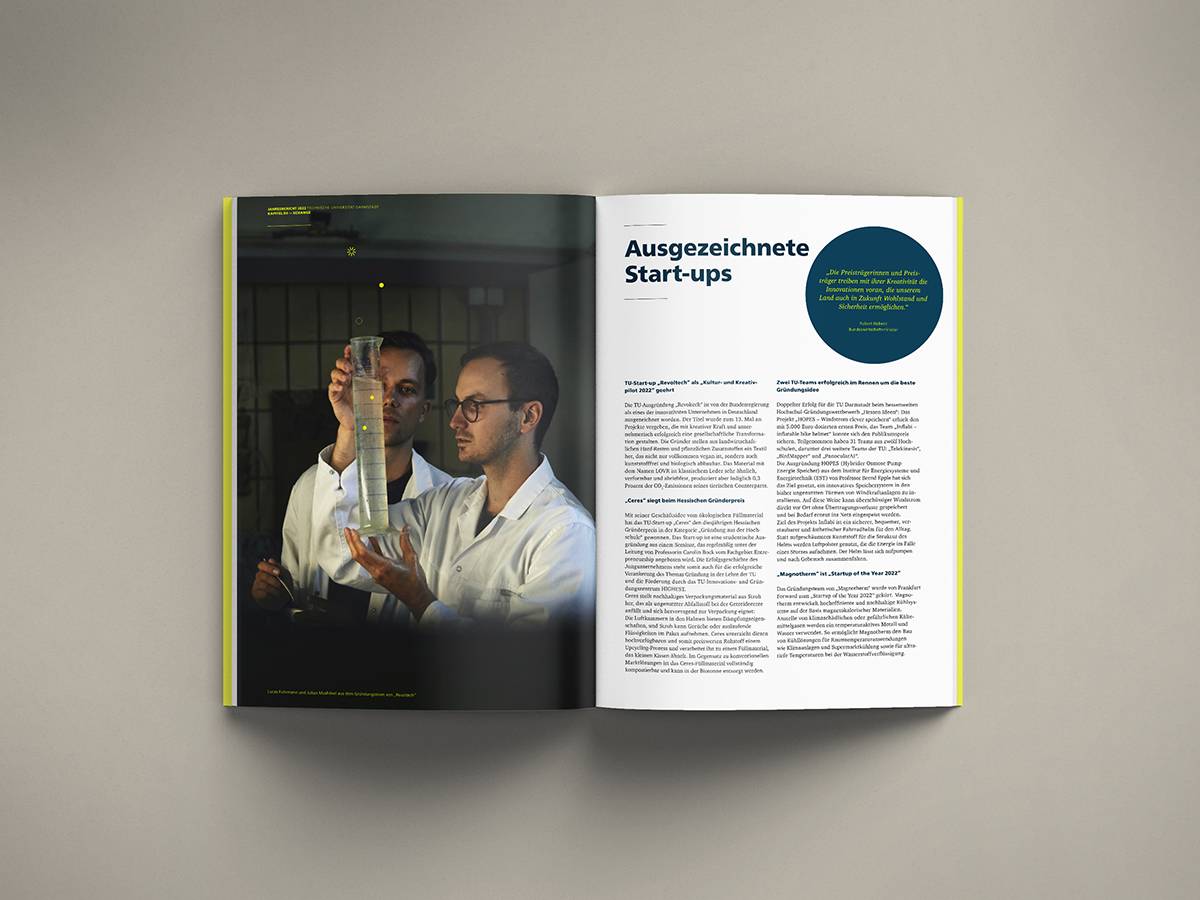 Aufgeschlagenes Magazin mit einem Foto von zwei Männern in Laborkitteln, die ein Messzylinder mit Flüssigkeit betrachten, und auf der rechten Seite Text mit der Überschrift „Ausgezeichnete Start-ups“.