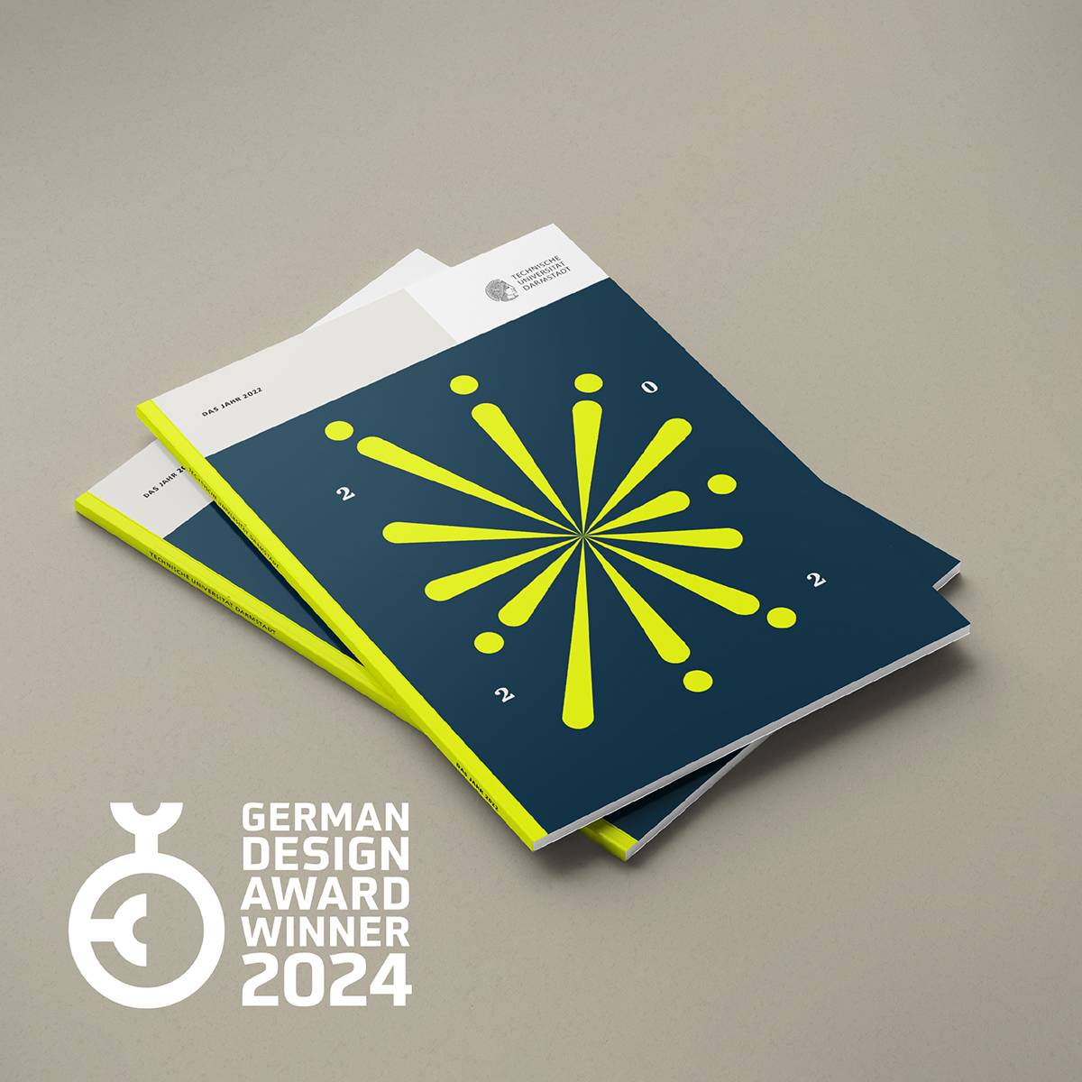 Zwei übereinanderliegende Broschüren mit dunkelblauem Cover, gelbem Strahlenmuster und der Aufschrift „2024“, daneben das Logo und der Schriftzug „German Design Award Winner 2024“.