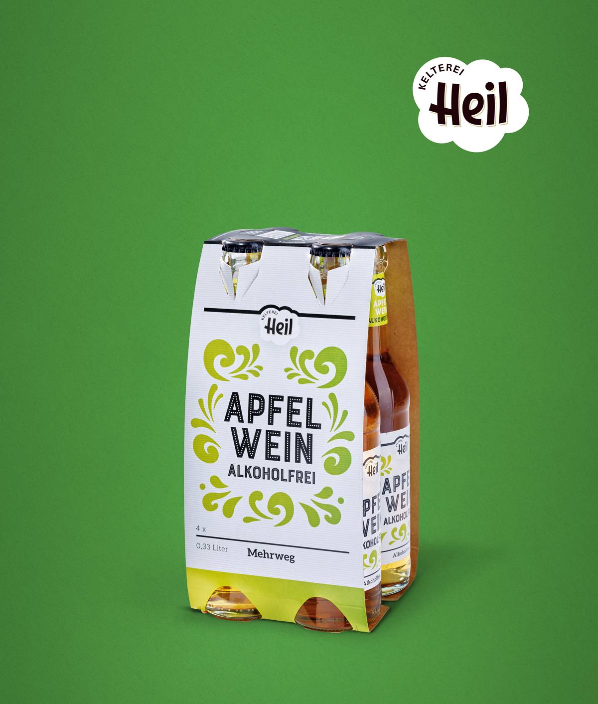 Viererpack Heil Apfelwein alkoholfrei in Glasflaschen mit weiß-grünem Tragekarton vor grünem Hintergrund.