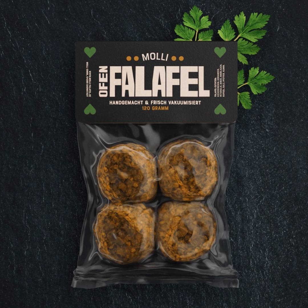 Vakuumverpackung mit vier Falafelbällchen, oben ein schwarzes Etikett mit der Aufschrift „OFEN FALAFEL“, im Hintergrund ein Zweig frische Petersilie.