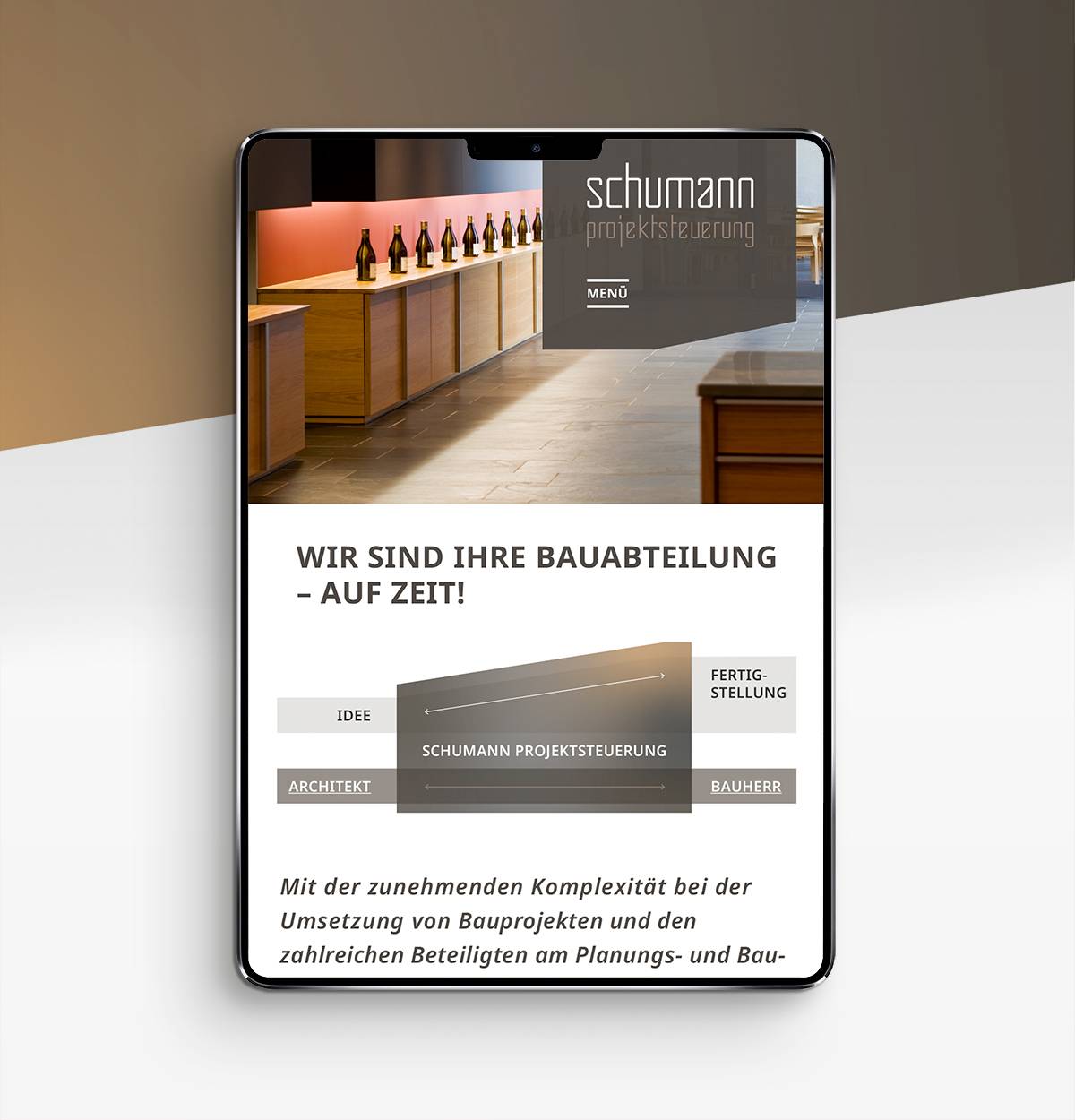 Tablet mit geöffneter Webseite von „schumann projektsteuerung“, die eine moderne Theke mit Flaschen, ein Organigramm zur Projektsteuerung und Text zur Bauabteilung zeigt.