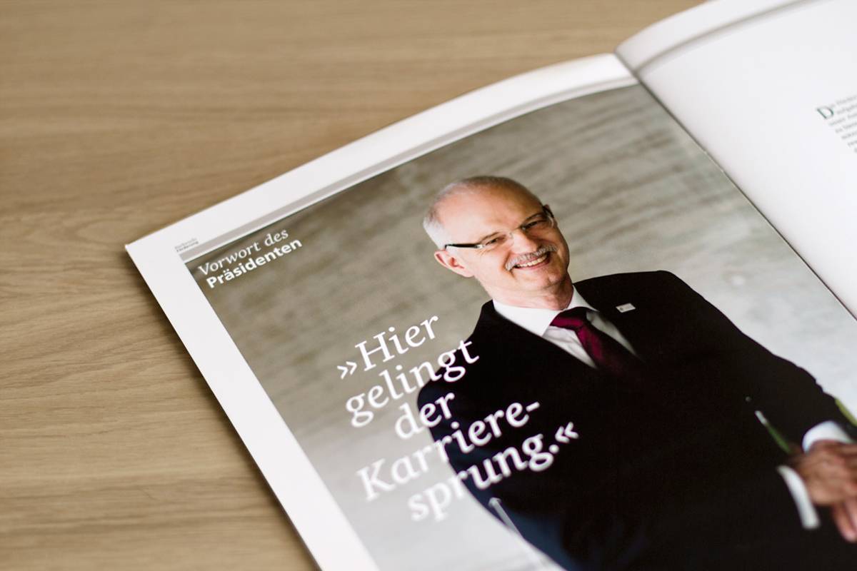 Aufgeschlagenes Magazin mit dem Foto eines lächelnden Mannes im Anzug und der Überschrift „Hier gelingt der Karrieresprung.“